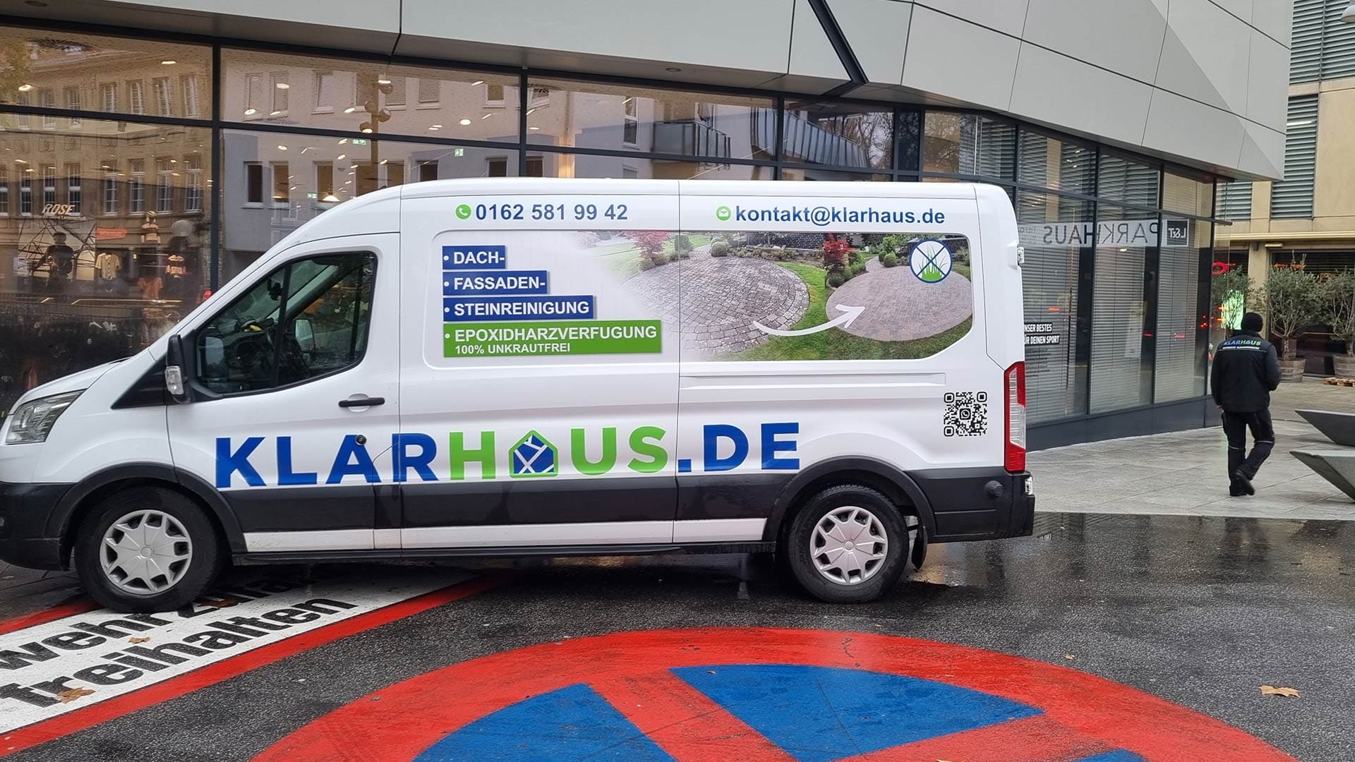 Lieferwagen mit Logo "Klarhaus.de", Infos zur Außenreinigung, weiße Karosserie, geparkte Stadtumgebung.