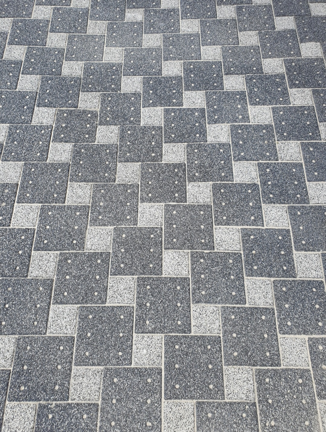 Grau und blau gemusterte Pflastersteine mit kleinen weißen Punkten in jedem Stein
