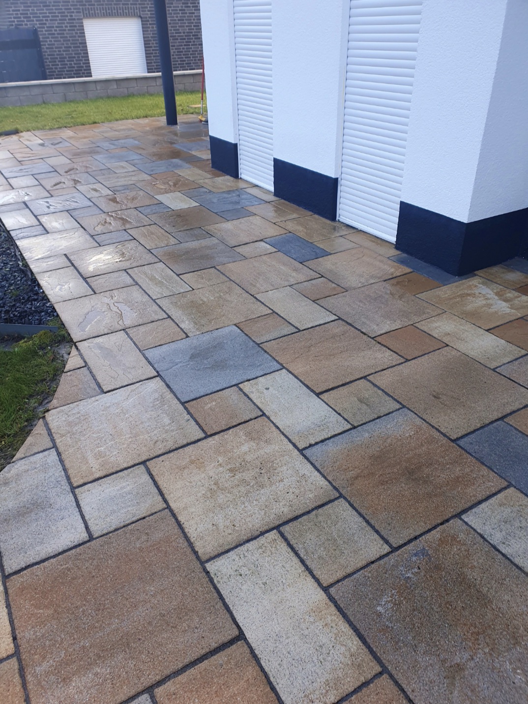 Ein frisch gereinigter, moderner Terrassenboden mit beigen und grauen Fliesen