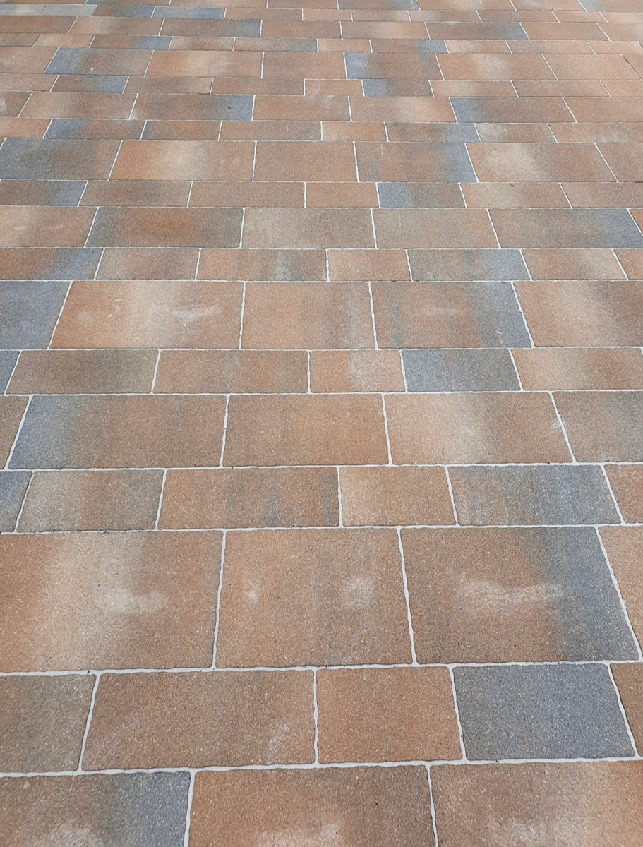 Braune und graue rechteckige Pflastersteine sind regelmäßig auf dem Boden angeordnet